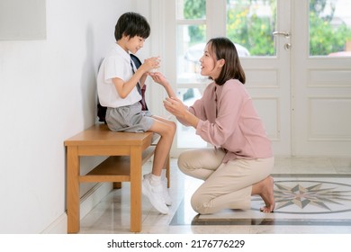Asian family, mother and her son drink a milk between set a student uniform before go to school