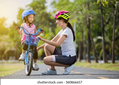 The Asian Family Mother Teaching Children Bicycle At The Park