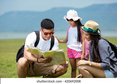 Asian Family Open Map Planning A Hiking Adventure