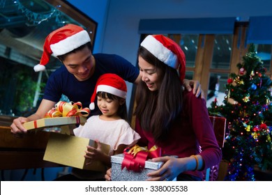 Asian Family Opening A Gift Box On Christmas Day Happy