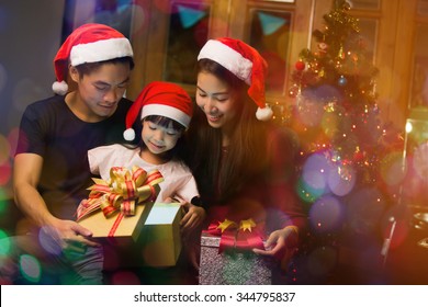 Asian Family Opening A Gift Box On Christmas Day Happy