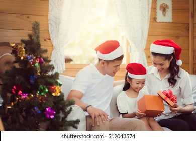 Asian Family Opening A Gift Box On Christmas Day Happy