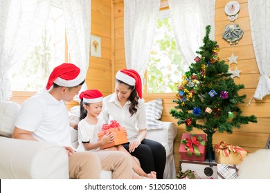 Asian Family Opening A Gift Box On Christmas Day Happy