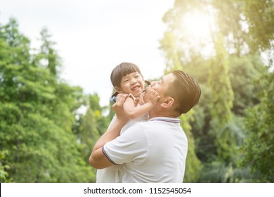 Asian Family Outdoors Portrait. Father And Daughter Having Fun At Garden Park. 