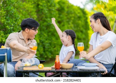 An Asian Family Of Parents And Daughters Camping With BBQ Tires. In The Front Yard Outside The House Together Happily