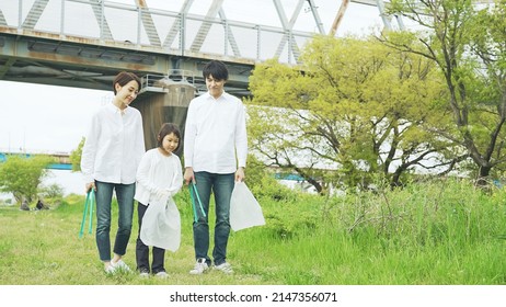 Asian Family Picking Up Trash In The Forest. Litter Cleanup Activities. Environment Protection. Recycling.