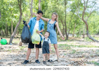 Asian family picking up trash in the forest. Litter cleanup activities. Environment protection. recycling. - Powered by Shutterstock