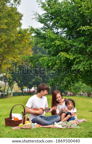 Asian family picnic in a garden in a public park. Asian family, outdoor activity, summer or happy family concept