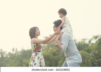 Asian Family Playing And Enjoying Quality Time Outdoor , Vintage Tone