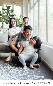 Asian Family Playing In The Living Room