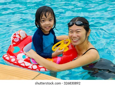 Asian Family Playing On Swimming Pool