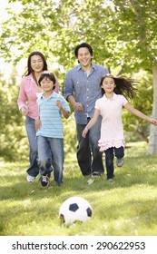 Asian Family Playing Soccerl In Park