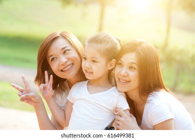 Asian Family Portrait At Nature Park, Morning Outdoor With Sun Flare.