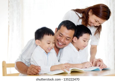 Asian Family Reading At Home