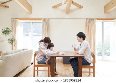 Asian Family Relaxing In The Living Room Of A Single House