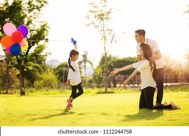 Asian family run and play in a garden, this immage can use for father, mother, kid and summer concept