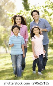 Asian Family Running In Park