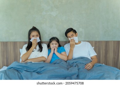 Asian Family Sick And Sneeze With Tissue Paper On A Bed In The Bedroom