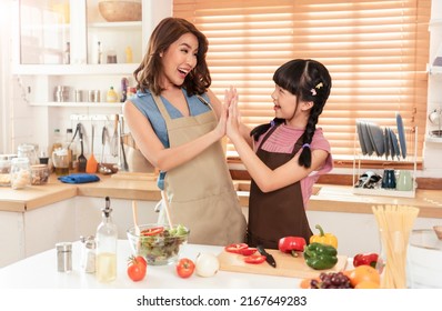 Asian Family, Single Mother And Daughter Teamwork Enjoy Cooking Prepare Salad Food Together In Kitchen Room At Home.