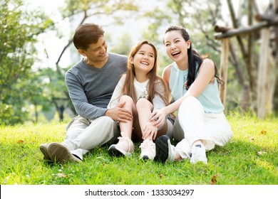 Asian Family Is Sitting And Chatting The Park, Which Is Ideal For Long Weekend Vacations. Taking Care Of Family Makes Children Feel The Love Of Parenting. Family Health Insurance Is A Good Plan.