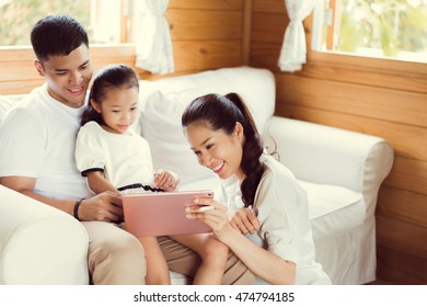 Asian family tablet uses a pen to write. are playing at home. - Powered by Shutterstock