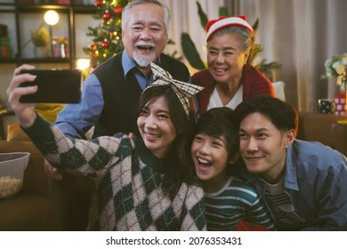 Asian Family Taking Selfie Near Christmas Tree Together At Home. Family, Holidays, Christmas Concept