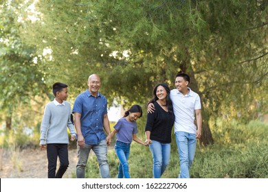 Asian Family Taking A Walk Outside And Talking.