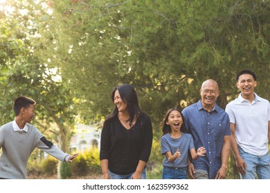 Asian Family Taking A Walk Outside And Talking.