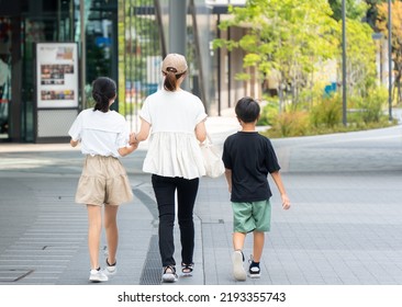 Asian Family Of Three Who Are Shopping