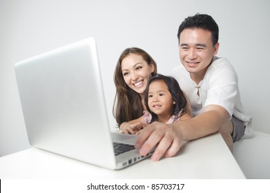 Asian Family Using The Laptop With The Daughter