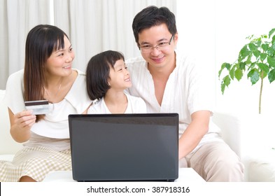 Asian Family Using Laptop To Perform Online Shopping