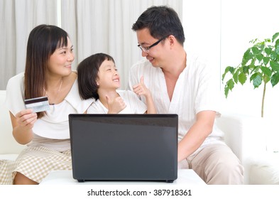 Asian Family Using Laptop To Perform Online Shopping