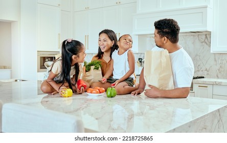 Asian, family and vegetables in kitchen for laugh at table, happy or comic in bonding. Mom, dad and children with smile at counter for funny, joke or crazy with bags after shopping in home in Jakarta - Powered by Shutterstock