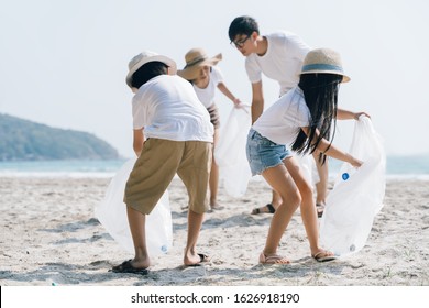 Asian Family volunteer picking up a plastic bottle on a beach with a sea to protect an environment - Powered by Shutterstock