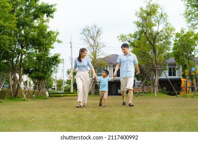 Asian Family Walking In Yard Or Public Park In Neighborhood For Daily Health And Well Being, Both Physical And Mental Happy Family.