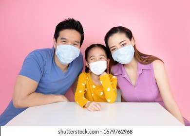 The Asian Family Is Wearing A Mask To Protect Against Viruses On Pink Background.