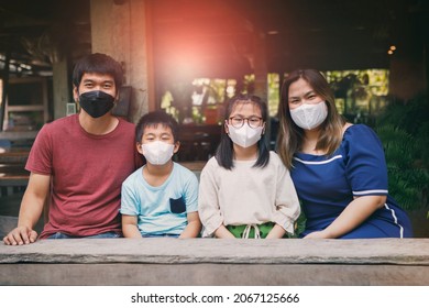 Asian Family Wearing Protection Face Mask Sitting In Thai Home