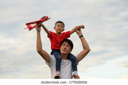 Asian Family.father's Day. Dad And Baby Son Playing Together Outdoors Paper Plane. Asian Family