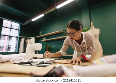 Asian fashion woman designer drawing design sketch. Female designer working in her fashion studio. - Powered by Shutterstock