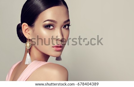 Asian  fashion woman  with Korean makeup style on face in pink dress. Oriental girl , cosmetics, cosmetology and fashion.Asia  beauty model  with tassel earrings . Accessories and  jewelry .