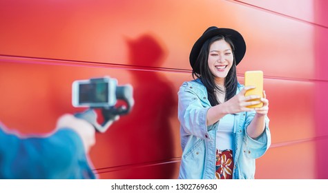 Asian Fashion Woman Vlogging And Using Mobile Smart Phone Outdoor - Happy Chinese Trendy Girl Having Fun Making Video With Gimbal Camera - Millennial People, Generation Z And Technology Concept 