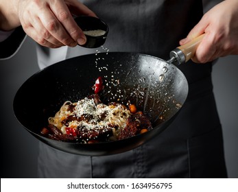 Asian Fast Food Rice Clear Noodles Cooking With Fried Meat And Spicy Vegetables By Cook Chef Hands In Wok Pan. Close Up Food Recipe Concept.