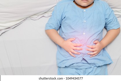 Asian Fat Child Suffering From Stomachache And Red Spot Indicating Location Of Pain. Healthy Concept