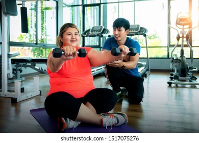 Asian Fat Girl Work Out And Weight Lifting With Her Trainer, This Image Can Use For Fat, Diet, Fitness And Exercise Concept