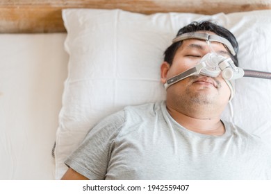 Asian Fat Man Wearing Cpap Mask Sleeping In Bed, Snoring Man.Obstructive Sleep Apnea Therapy. Cpap Therapy, Medical Health, Sleep Test, Good Sleep, Machine, Patient, Sleep Disordered Breathing.Sdb 