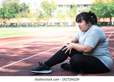 Asian Fat Woman, Is Currently Having A Knee Injury During His Exercise By Running In The Running Track At The Park, Due To Osteoarthritis, To Sports And Health Care Concept.