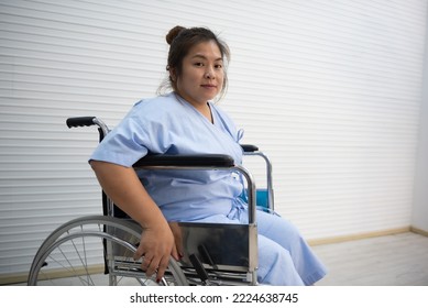 Asian Fat Woman Patient Sitting On A Wheelchair, Knee Pain, Excessive Weight , Health Care Concept. 