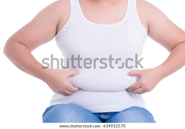 アジアの太った女性は太り過ぎだ 彼女は腹部の余分な脂肪を握る手を使った 白い背景に 彼女は痩せたいと思っている 手術と皮下脂肪分解のコンセプト の写真素材 今すぐ編集