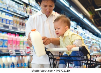 Asian Father & Cute Little 18 Months Old Toddler Boy Child Choosing Milk Product In Grocery Store, Dad Read Milk Nutrition Facts With Child Sit In Shopping Cart, Kid First Experience Concept