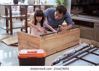 Asian Father And Daughter Assembling New Furniture At Their Home